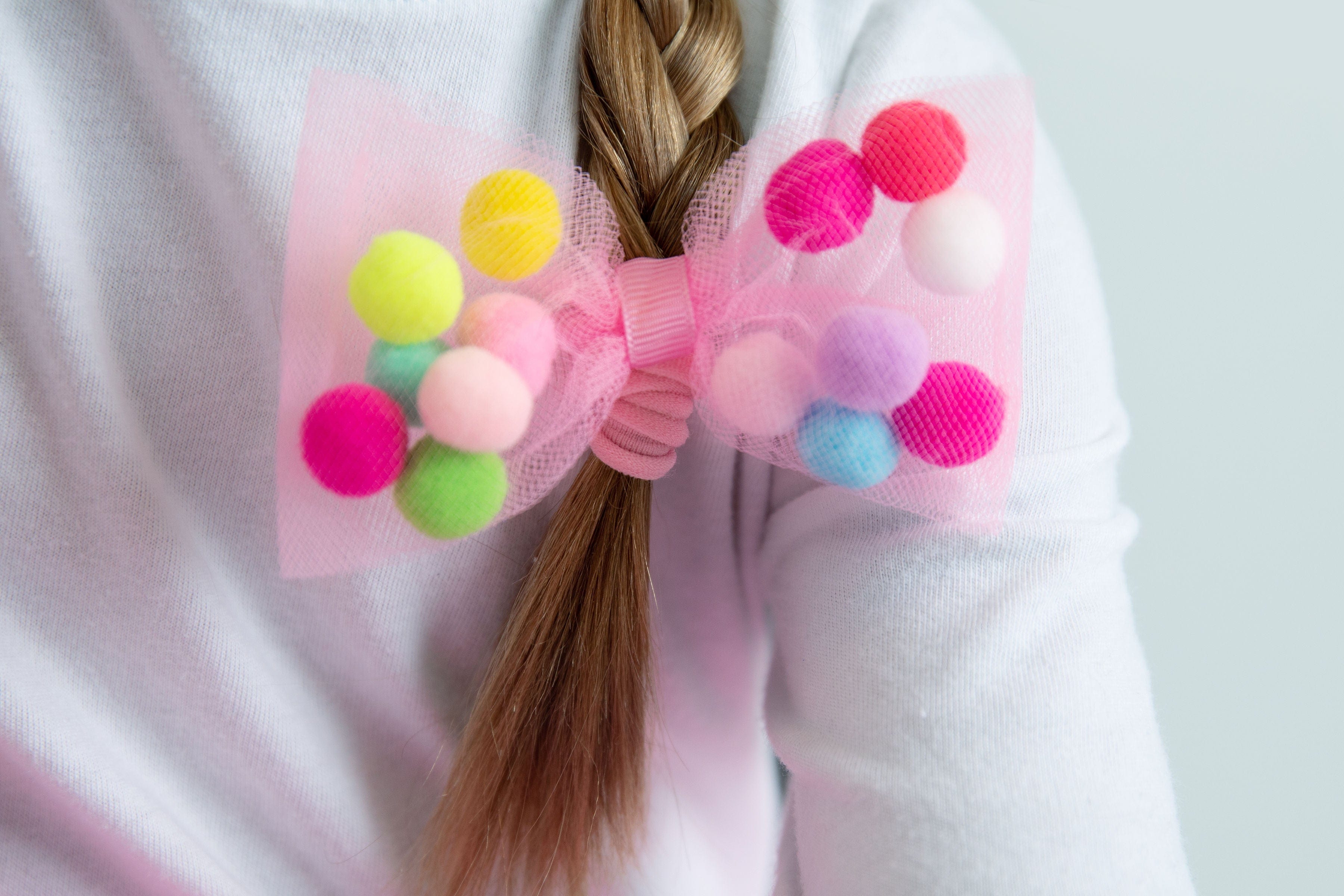 pink tulle bow hair tie with pom pom balls by tutu joli