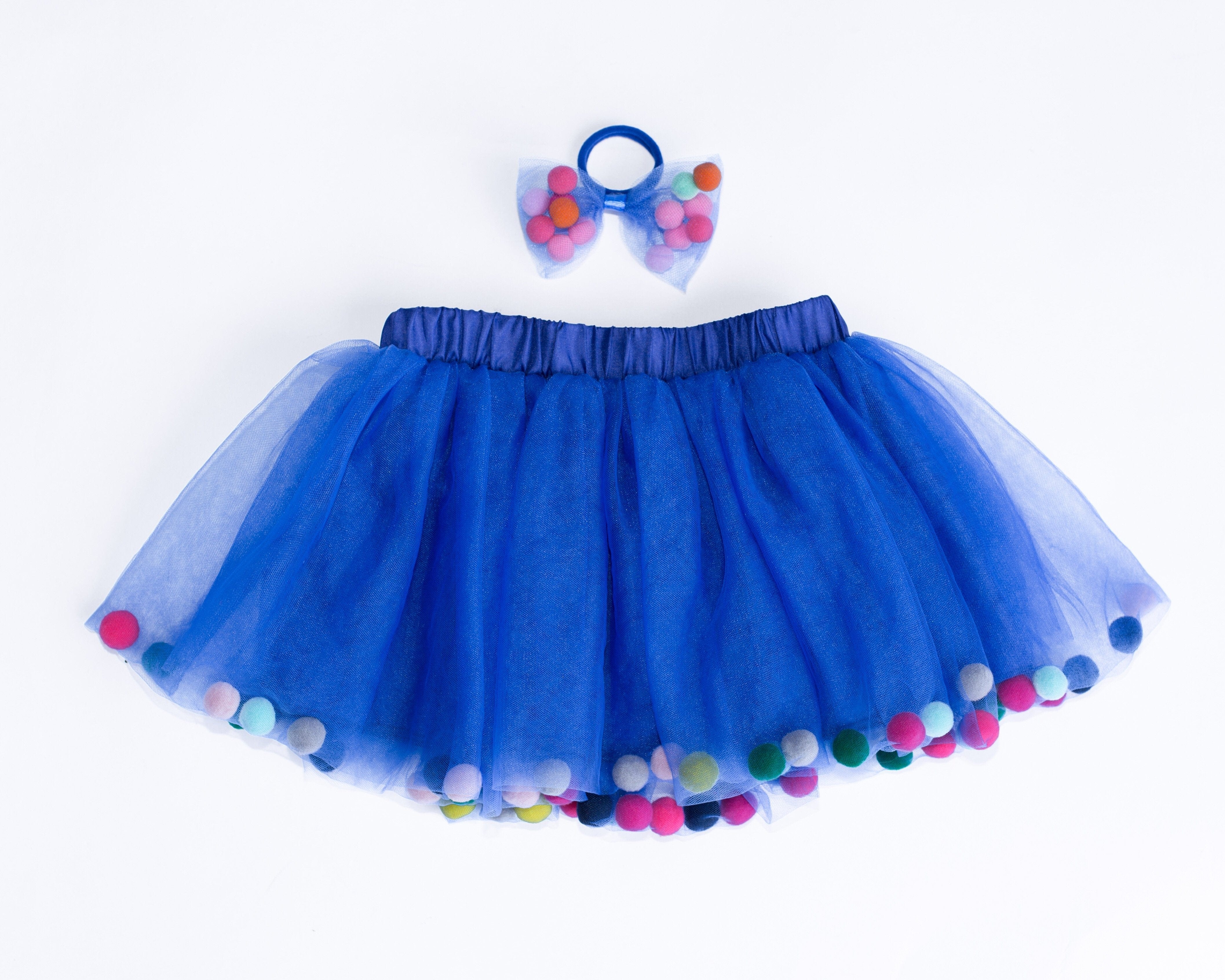 pom pom hair tie bow for children, designer hair ties, designer kids accessories, tutu joli blue pom pom tutu skirt, pom pom tutu, royal blue tutu skirt for toddlers, blue pom pom hair bow, pom pom bow ponytail holder in navy blue, pom pom hair accessories, birthday tutu blue, rainbow pom pom balls tutu, tootoo, pompoms, royal blue tutu skirt, navy blue tutu with poms, pompoms, blue tootoo for kids, children’s fashion 2020, kids ballet tutu skirt in blue, baby ballet tutu skirt in blue